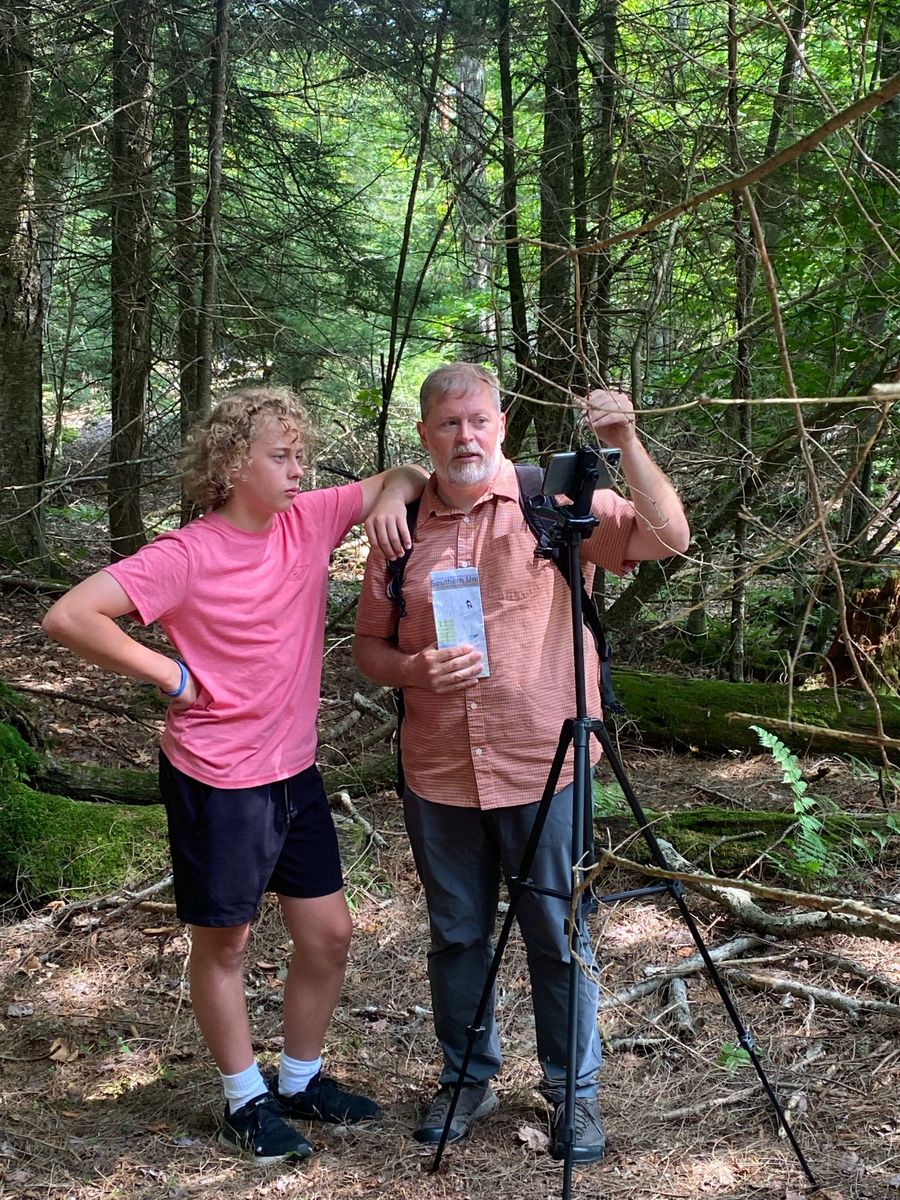 Filming a video on a tripod in the woods